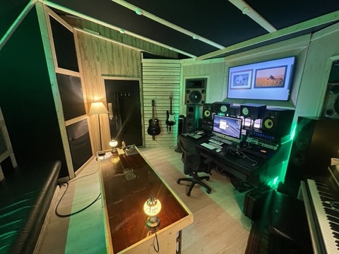 Control room from the couch, with two electric guitars mounted on the wall